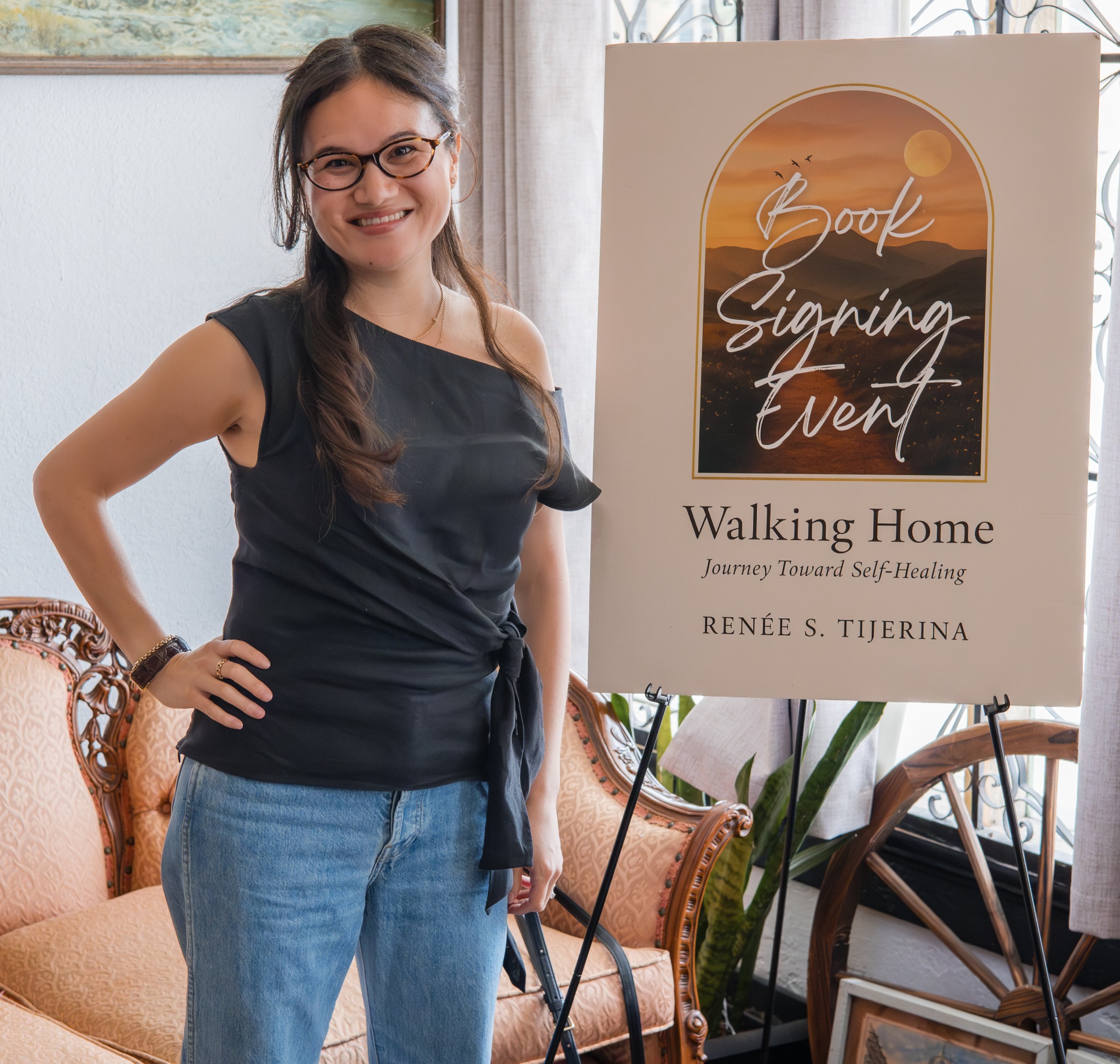 Renée S. Tijerina beside the Walking Home author signing event sign